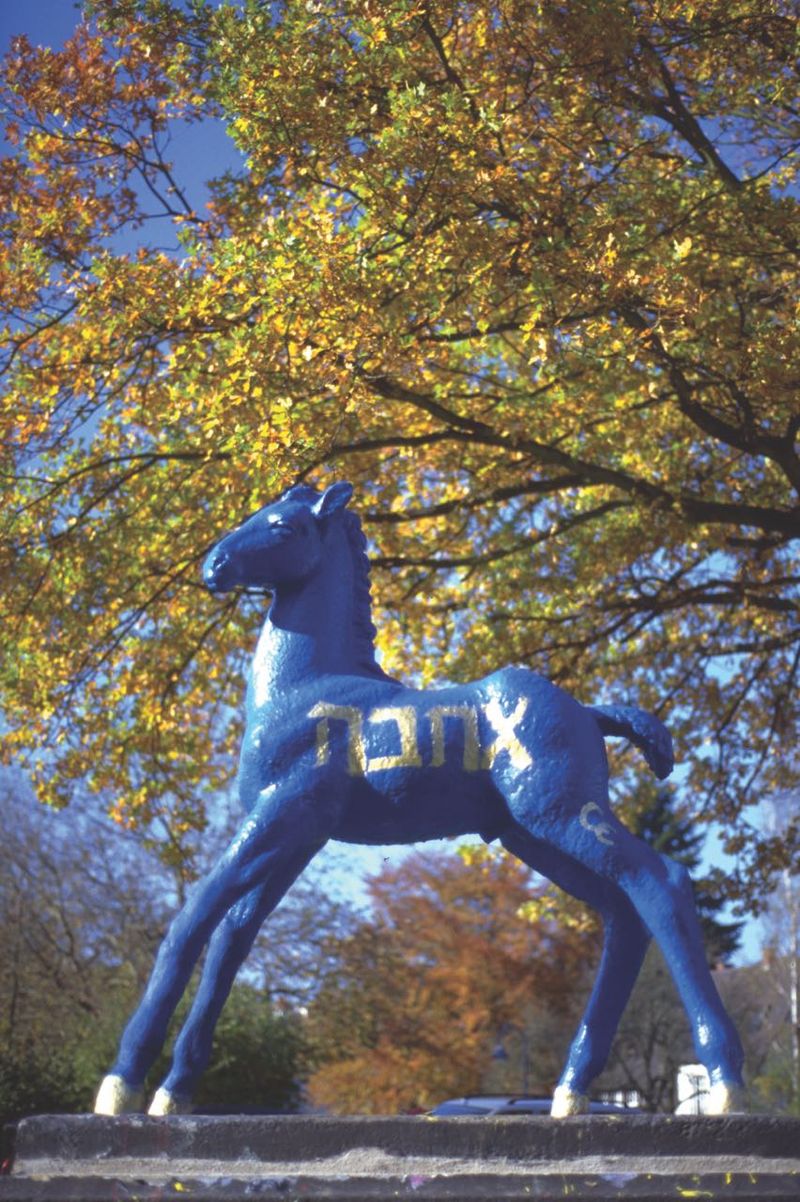 Holbein-Pferd blau mit hebräischer Schrift im Herbstlaub