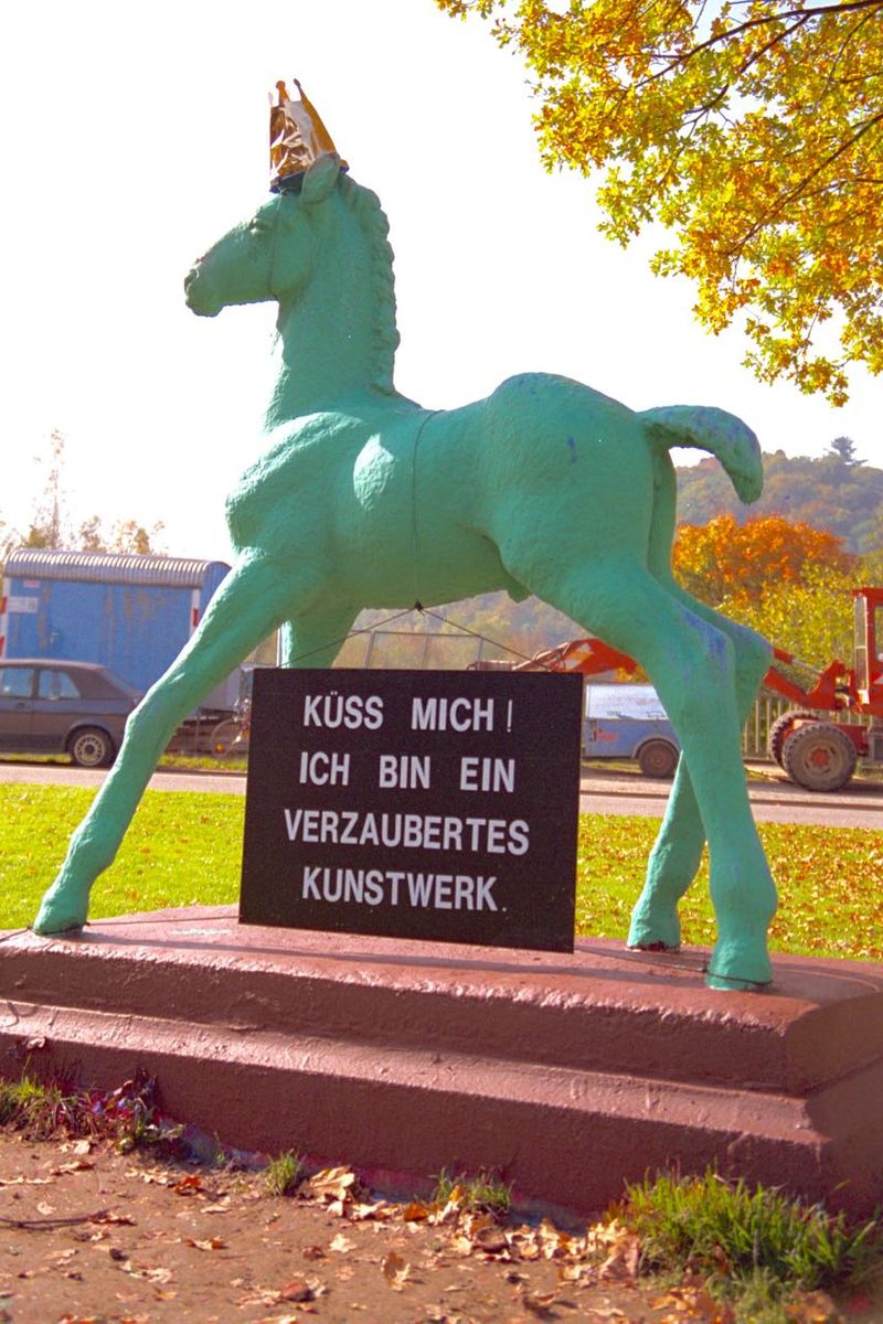 Holbein-Pferd grün mit Schild „Küss mich! Ich bin ein verzaubertes Kunstwerk“