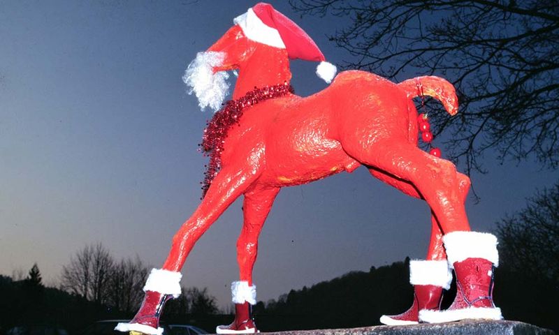 Holbein-Pferd rot mit Weihnachtsmütze und Stiefeln als Santa Claus
