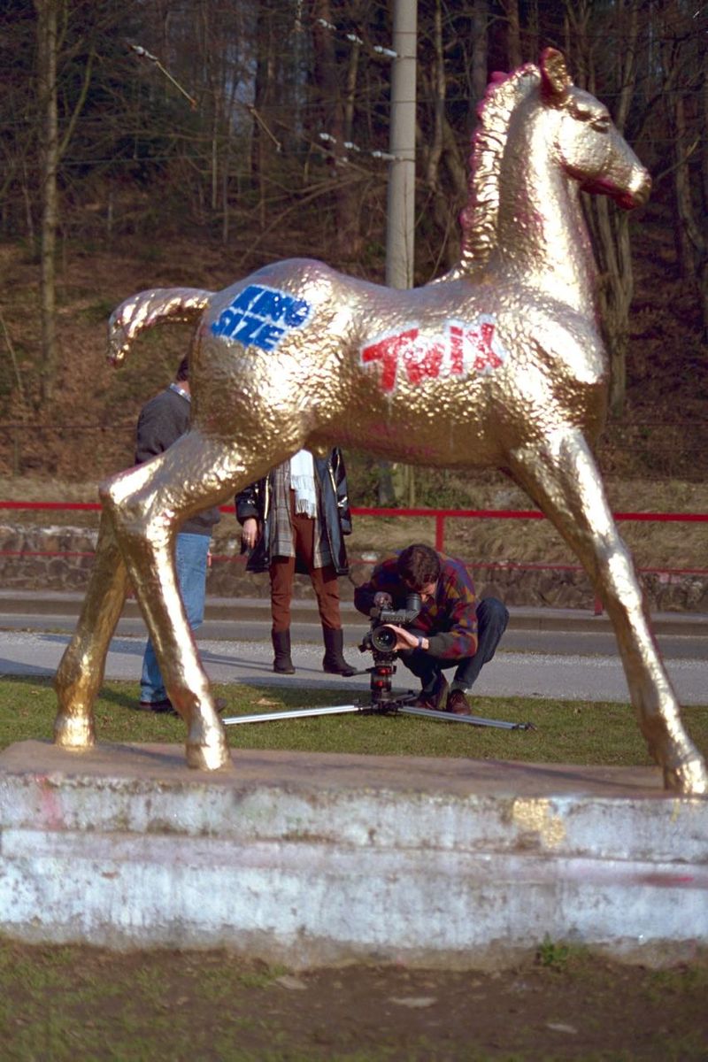 Holbein-Pferd gold mit Twix-Logo, ein Mann fotografiert davor